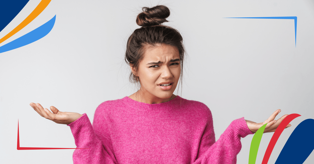 A person in a pink sweater with their hands outstretched and a confused expression on their face.