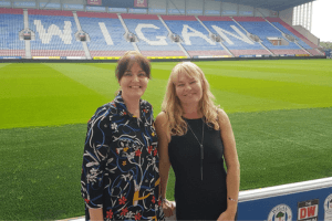 Jo Leigh and Nichola Howard from Launch North West stood pitch side at the DW stadium, Wigan