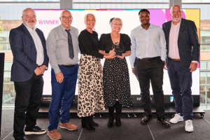 Launch North West founders receiving the Marketing Impact Award at the Greater Manchester Chamber Excellence Awards, standing with presenters and holding the award trophy.