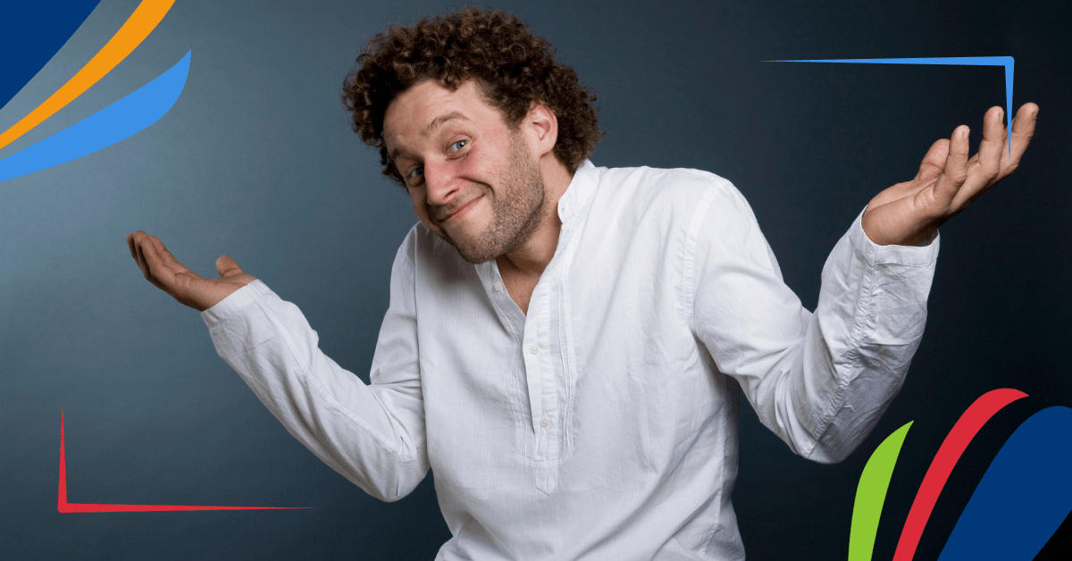 A person with curly hair wearing a white shirt and khaki pants, shrugging with open palms.