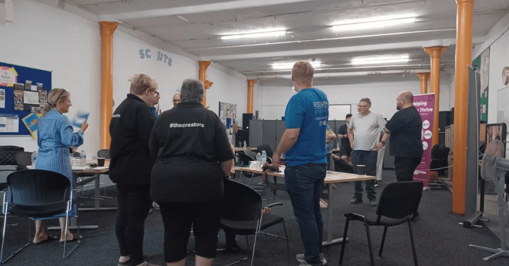 A room full of people attending a networking event, standing in small groups and talking with one another